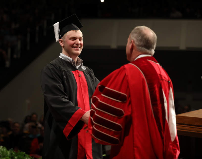 Graduating history major Nathan Van Neste receives congratulations from Union University President Dr. Samuel W. Dub Oliver upon receiving his diploma on December 14, 2019. Photo by Kristi Woody