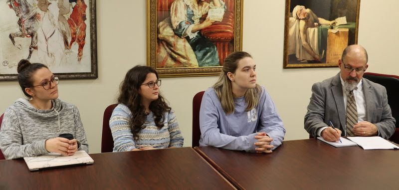 Attendees listen to Leah Atkins present her honors thesis on Poisonous Women: Gender and Power in Ancient Rome on December 9, 2019. They are (left to right) Katie Allison, Madison Morris, Ashley Perkins, and Dr. Scott Huelin.