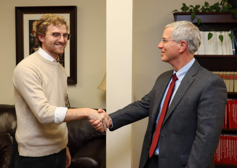Dr. David Thomas, the chair of Luke Sower's honors thesis committee, congratulates Sower on his successful   thesis defense on December 3, 2019.