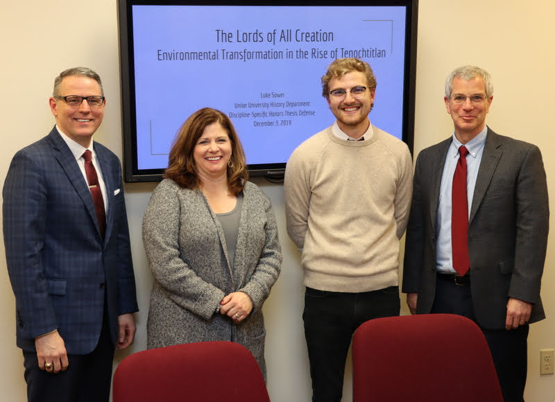 Luke Sower (second from right) stands with members of his honors thesis committee following his successful thesis defense on December 3, 2019. They are (left to right) Dr. Keith Bates, Dr. Karen Martin, and thesis director Dr. David Thomas.