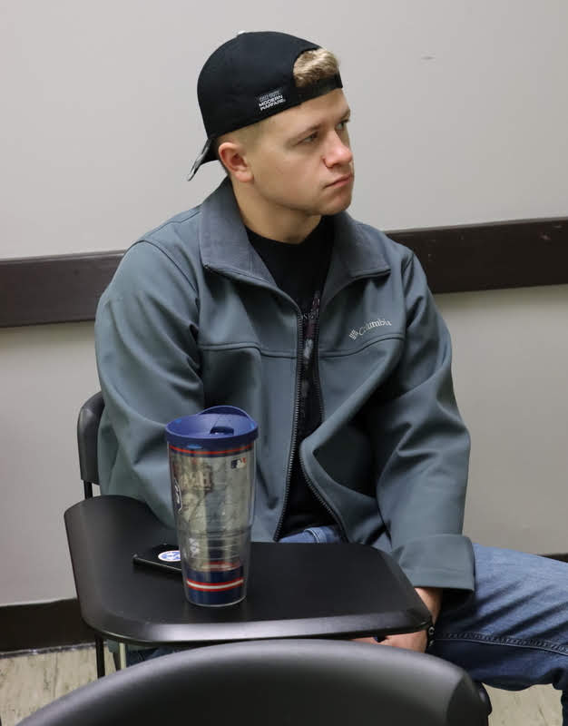 Braden Barland listens during the history club's fall plenary meeting on November 11, 2019, as President Leah Atkins announces the movie for the club's pizza party/movie night on November 21.