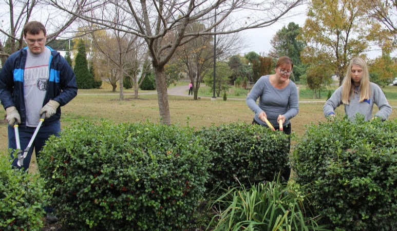 Miles Randall (left to right), Tammy Buchanan-Anderson, and Addison Osborne trim shrubs at Liberty Garden Park on October 29, 2019.