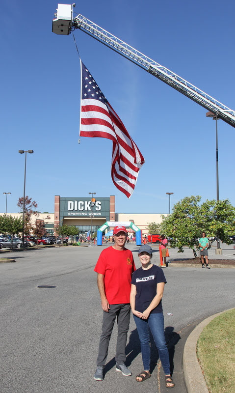Robert Briley and Megan Ledbetter stand near the finish line following the Racing So They Can Ride 10k race at Dick's Sporting Goods on September 21, 2019.