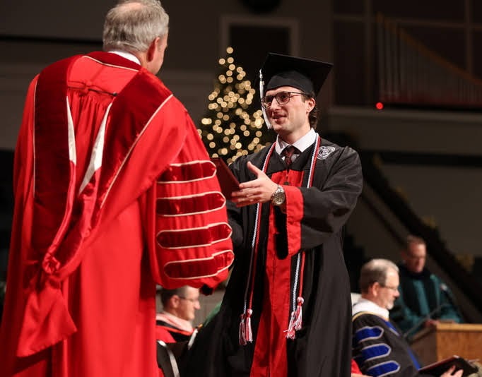 Graduating history minor Joseph Gee accepts his B.A. diploma from President Samuel W. Dub Oliver at Union University's fall commencement on December 11, 2021. Photo by Kristi Woody