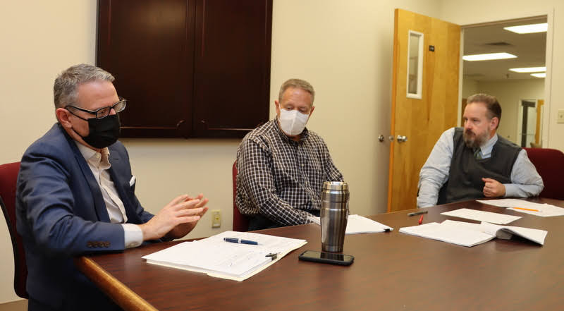 Dr. Keith Bates (left) comments on Jack Waters' honors thesis during Waters' thesis defense on December 8, 2021. Dr. Henry Allen (center) and Mike Garrett (right) listen.