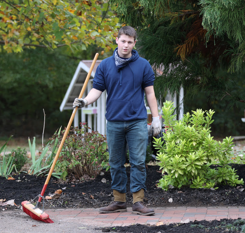 Rutledge Honorary History Club member Noah Kea sweeps a sidewalk at Liberty Garden Park as part of the history department's community service project on November 2, 2021. Photo by Kristi Woody