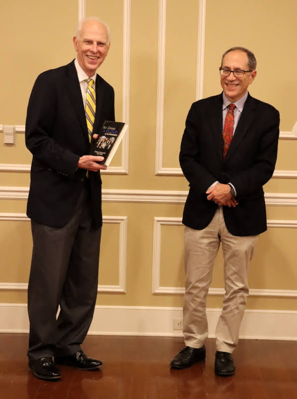 Dr. Stephen Carls (left) presents a book to Dr. David Bell at a dinner in honor of the Princeton professor on October 25, 2021.