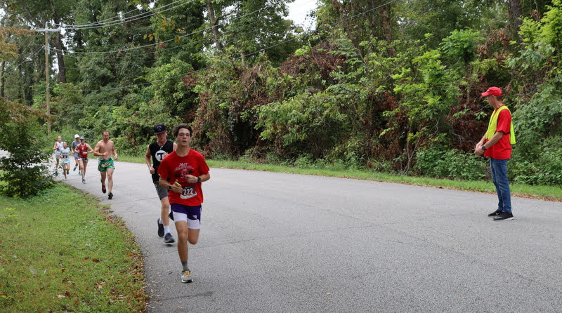 Phi Alpha Theta volunteer Robert Briley (right) cheers on runners at the Racing So They Can Ride races on September 18, 2021.