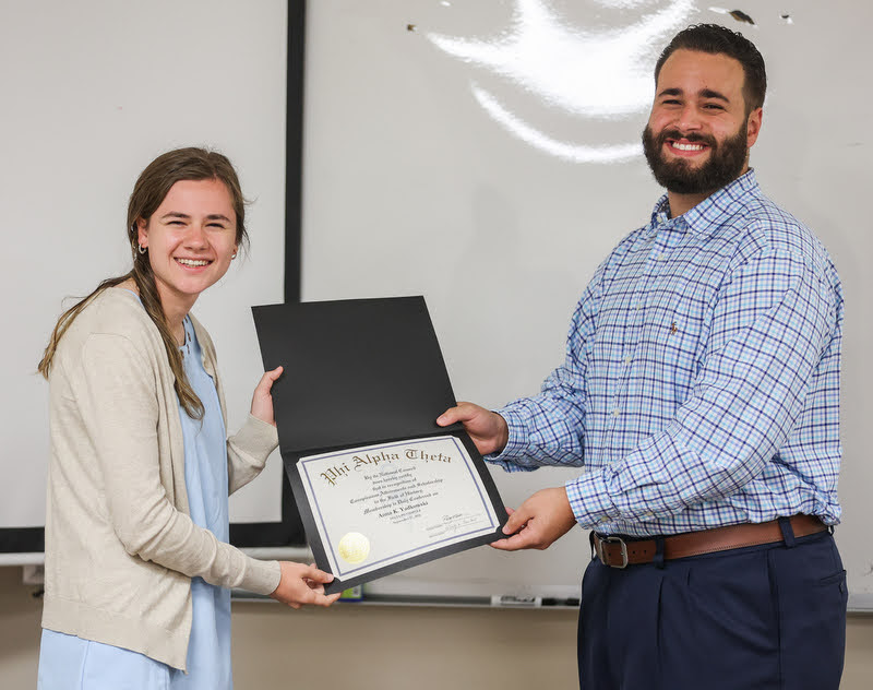 Anna Yadkowski receives her Phi Alpha Theta membership certificate from Delta-Psi Chapter President Nick Terra on September 27, 2021. Photo by Kristi Woody