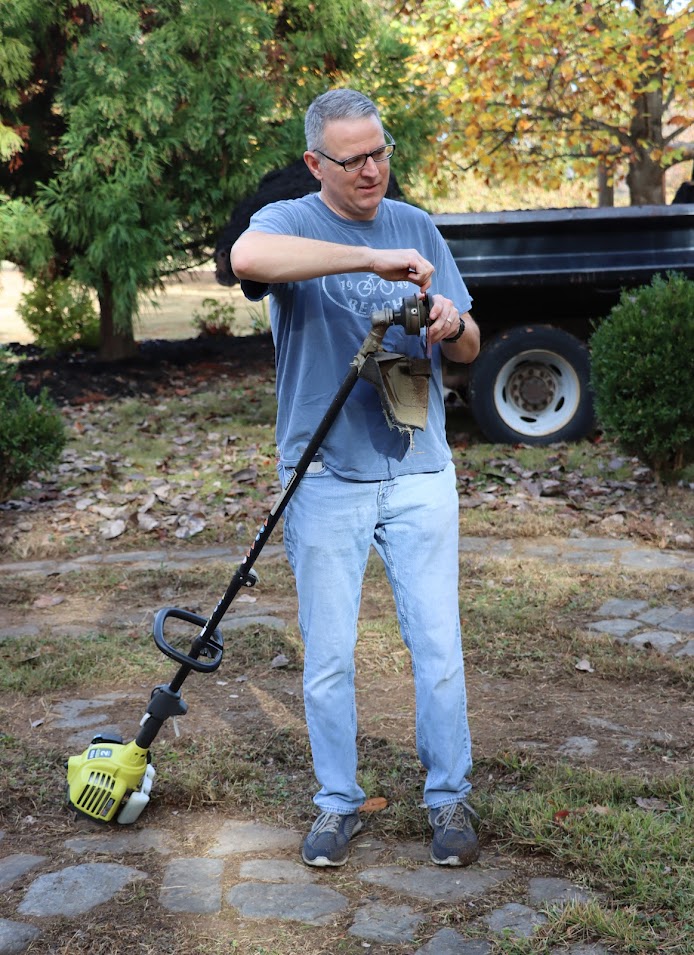 Dr. Keith Bates attends to his string trimmer during the history department's community service project at Liberty Garden Park on November 1, 2022.