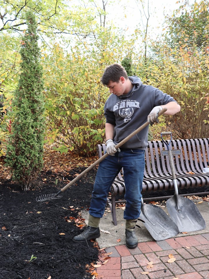 Union University student Noah Kea smooths out mulch at Liberty Garden Park as part of the Phi Alpha Theta/history club-sponsored community service project there on November 1, 2022.
