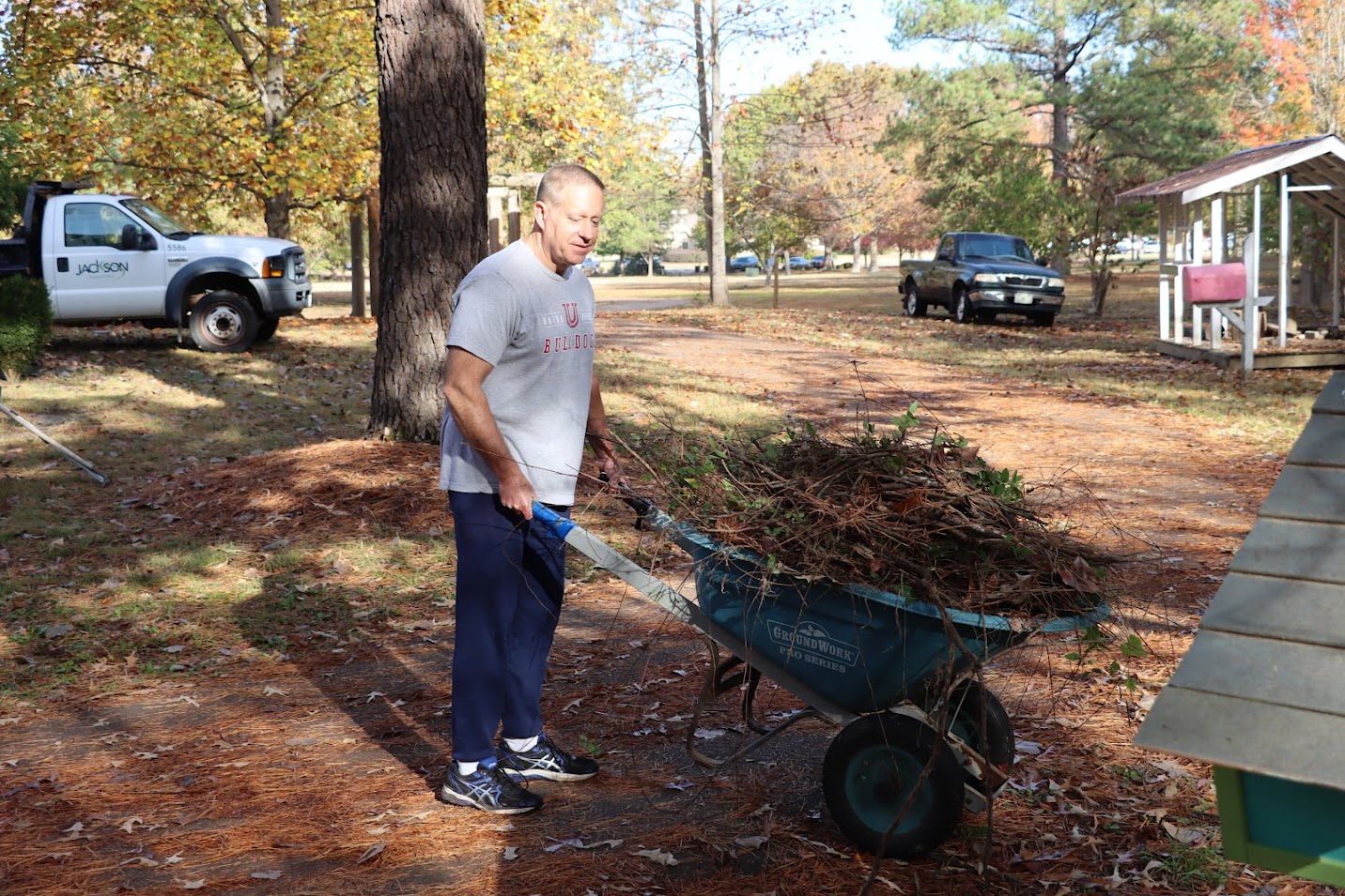 Dr. Henry Allen moves a wheelbarrow full of twigs and branches at the Phi Alpha Theta/history club community service project at Liberty Garden Park on November 1, 2022.