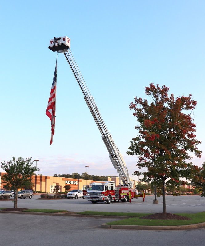 An American flag hangs from the top of a City of Jackson hook-and-ladder fire truck  near the starting point of the Racing So They Can Ride 5k and 10k races at Dick's Sporting Goods on the morning of September 17, 2022.