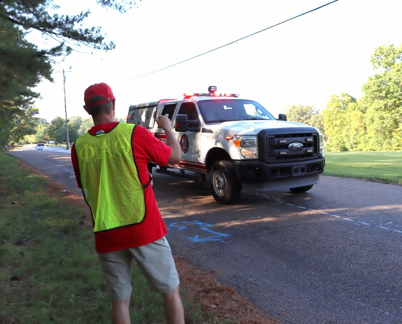 Phi Alpha Theta member Robert Briley greets a City of Jackson fire truck as it provides safety for runners in the Racing So They Can Ride races on September 17, 2022.