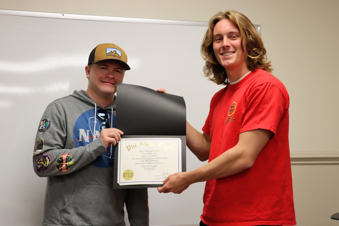 Delta-Psi Chapter President Tad Binkley (right) presents John Garland with his Phi Alpha Theta membership certificate on September 26, 2022.