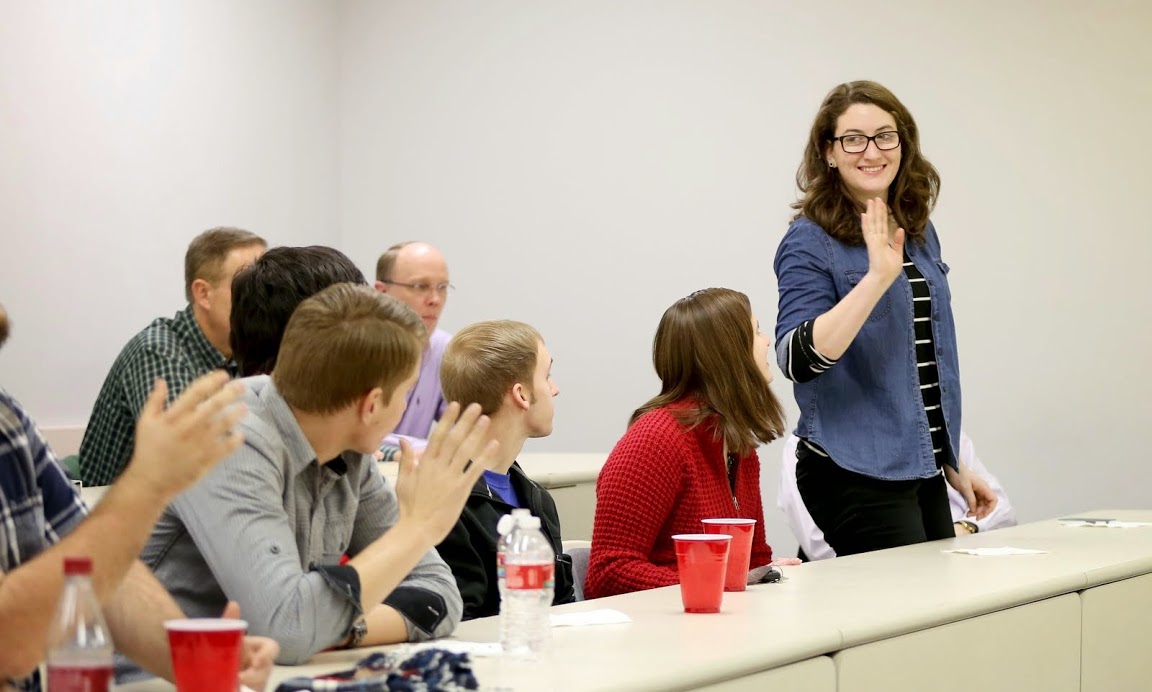 New initiate Olivia Winters waves to faculty and students present at the Phi Alpha Theta plenary meeting during her introduction on February 24, 2015.  Photo by Kristi Woody
