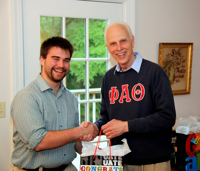 Graduating history major Kenan Keller receives a graduation bag and congratulations from Dr. Stephen Carls at the 23rd Annual Phi Alpha Theta/History Department Cookout on May 8, 2015.