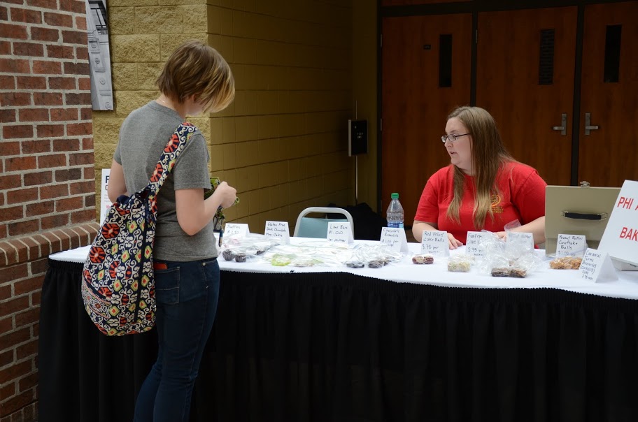 Hannah Conway (right) waits on a student at the Phi Alpha Theta bake sale on April 20, 2016.