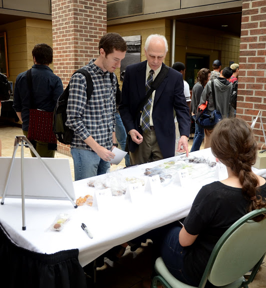 Union University history student Luke Adkins (left) listens to Dr. Stephen Carls discuss a sales item at the Phi Alpha Theta bake sale on April 20, 2016. Delta-Psi member Olivia Winters sits behind the sales tale. Photo by Mikalla Cotton