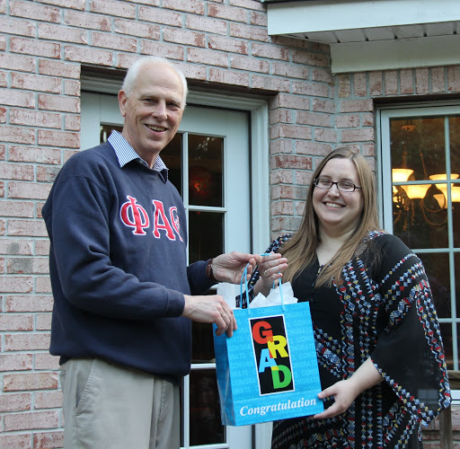 Hannah Conway accepts a graduation bag from Dr. Stephen Carls at the Phi Alpha Theta cookout on May 13, 2016.
