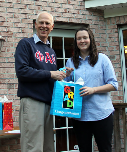 Graduating senior Lauren Geary receives a gift bag from Dr. Stephen Carls at the Annual Phi Alpha Theta/History Department Cookout on May 13, 2016.