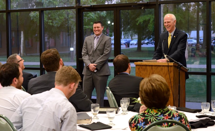 Dr. Stephen Carls (right, standing) shares a bit of humor during his presentation of J. Jason Williams (left, standing) as the 2016 recipient of the History Alumni Distinguished Achievement Award at the history awards banquet on May 5, 2016. Photo by MiKalla Cotton