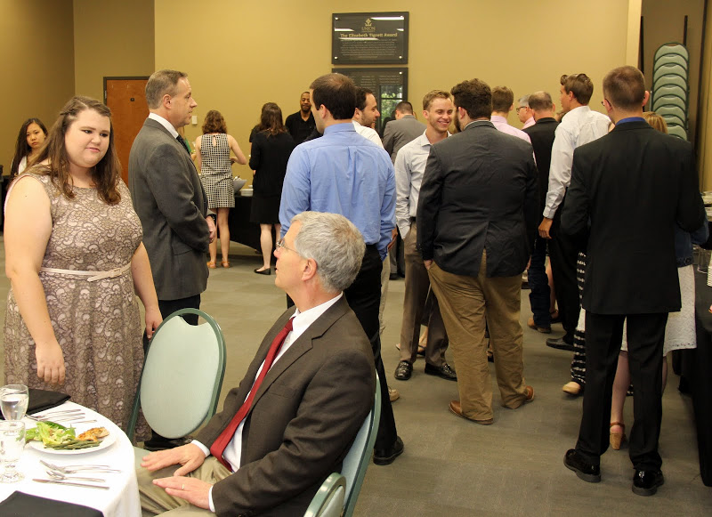 Attendees at the History Department Awards Banquet on May 5, 2016, engage in conversation and wait in line to get their food. In the foreground on the left are Jessica Barton and Dr. David Thomas (seated).