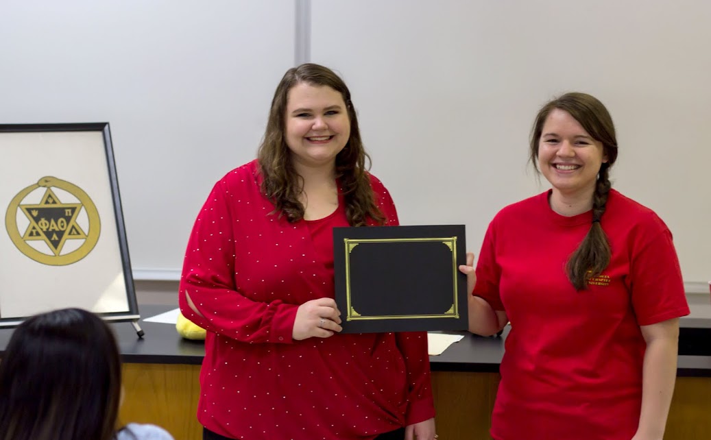 Delta-Psi President Jordan Sellers (right) presents newly inducted Jessica Barton with her Phi Alpha Theta membership folder at the society's plenary meeting on February 20, 2017. Photo by Morgan Morfe