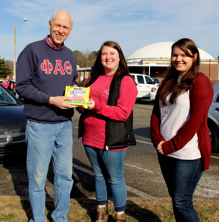 Dr. Stephen Carls accepts a package of Peeps Oreo Cookies from Phi Alpha Theta members Kathryn Mitchell (center) and Jordan Sellers (right) following the Jackson Old Hickory Rotary Club's pancake breakfast on March 18, 2017.