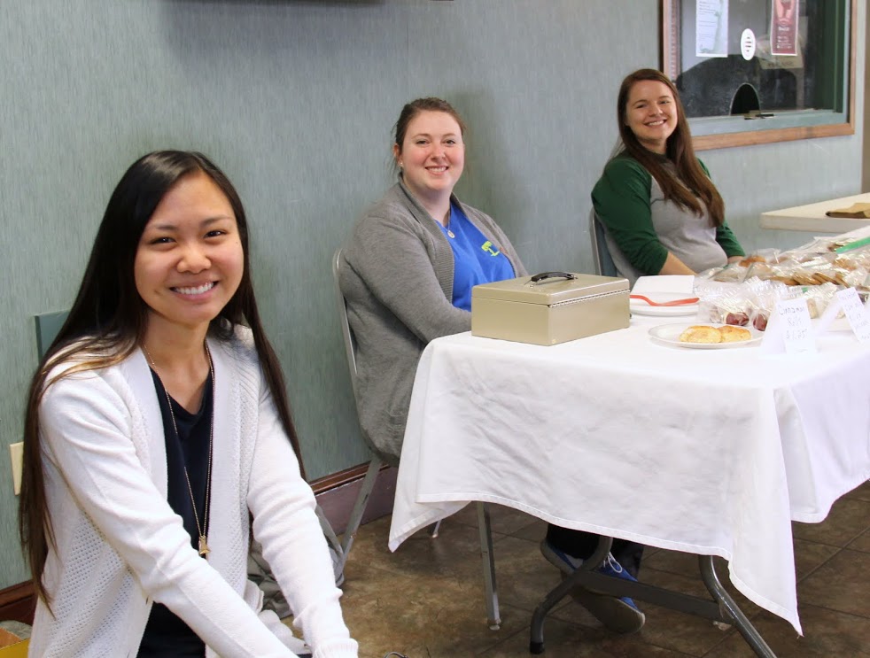 Phi Alpha Theta members Katherine Cheshire (left to right), Kathryn Mitchell, and Jordan Sellers get ready to sell items at the Franco-American bake sale to students leaving the morning chapel service on March 22, 2017.