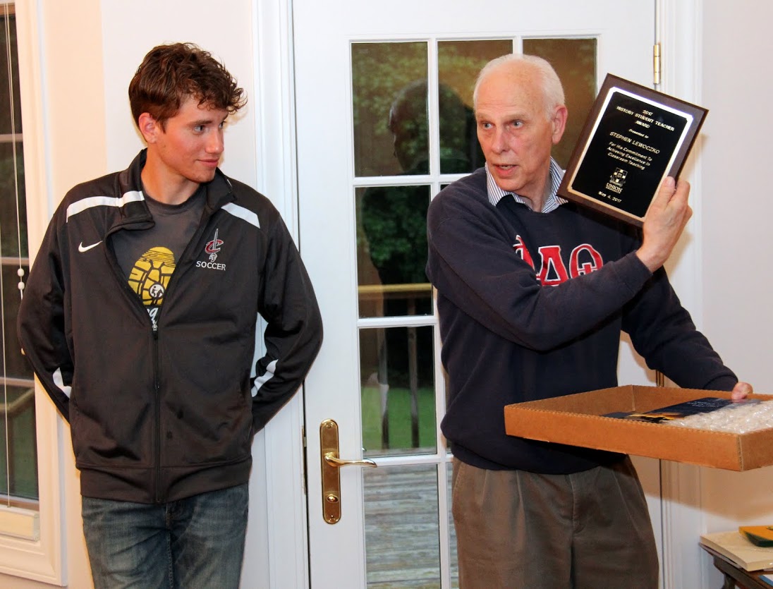 Graduating senior Stephen Lewoczko (left) observes as Dr. Stephen Carls presents him with the History Student Teacher Award at the Phi Alpha Theta cookout on May 12, 2017.