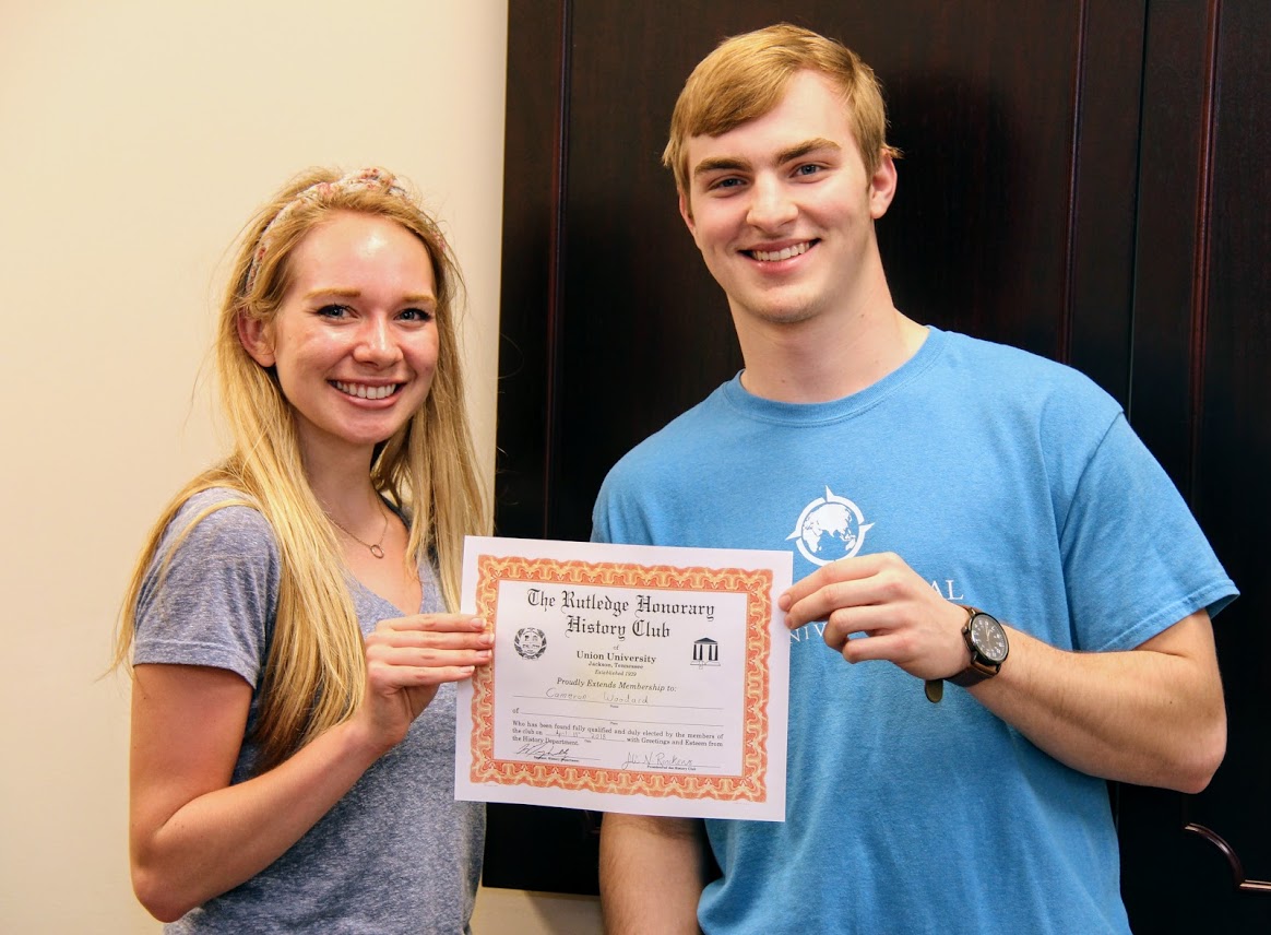Rutledge Honorary History Club President Ali Renckens presents Cameron Woodard with his certificate of membership on April 13, 2018.