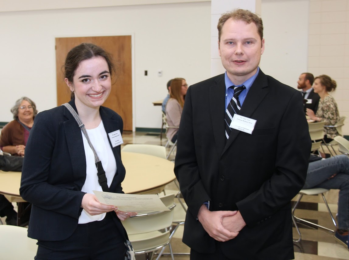 Leah Atkins accepts the third place award in the student papers competition from conference coordinator Dr. John Henris at the Arkansas Phi Alpha Theta Regional Conference on April 7, 2018.
