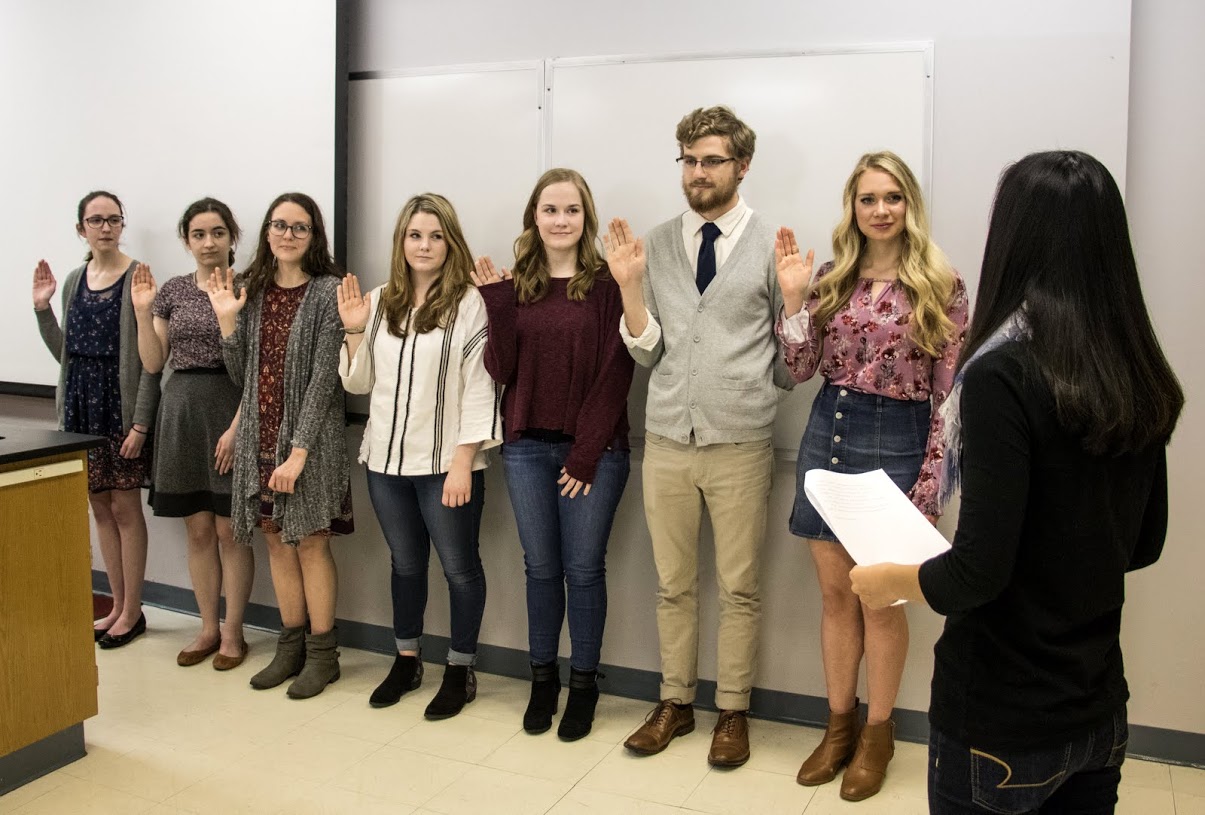 Delta-Psi Chapter Vice President Katherine Cheshire (right, back to camera) leads the induction ceremony for incoming Phi Alpha Theta members. They are (left to right) Lauren Butler, Leah Atkins, Katie Allison, Alex Barger, Megan Ledbetter, Luke Sower, and Ali Renckens. Photo by Janelle Vest