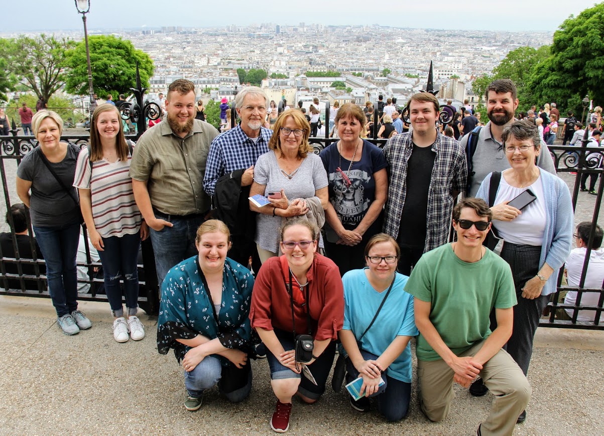 World War I course participants stand on the hill of Montmartre in the north of Paris, with much of the city behind them. They are: (kneeling, left to right) Susannah Murphine, Emily Hedges, Mary Long, and Samuel Walgren; (standing, left to right) Wendy Lay, Ansley Moore, Alex Carr, Rick Rickard, Ronda Rickard, Jeanne Reed, Micah Pinkley, Christopher Ray, and Dr. Alice-Catherine Carls.