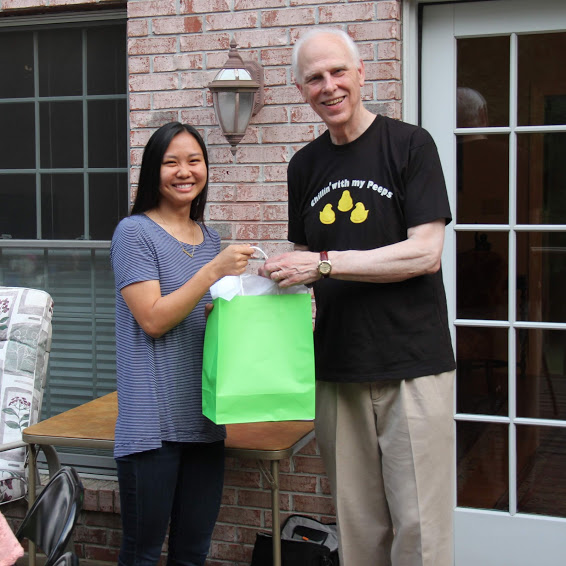 Phi Alpha Theta member Katherine Cheshire accepts a graduation gift bag from Dr. Stephen Carls at the history department cookout on May 12, 2018.