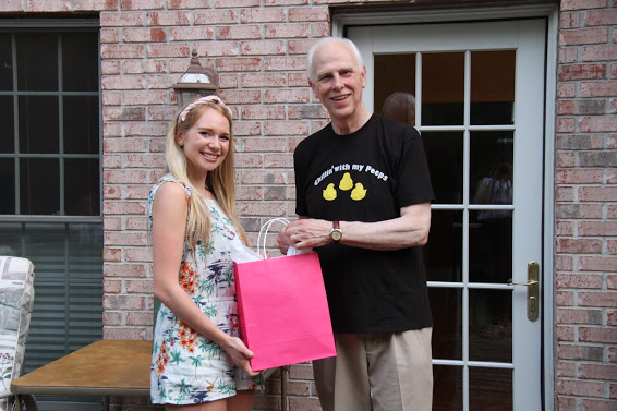 Dr. Stephen Carls presents a graduation gift bag to Phi Alpha Theta member Ali Renckens at the history department cookout on May 12, 2018.
