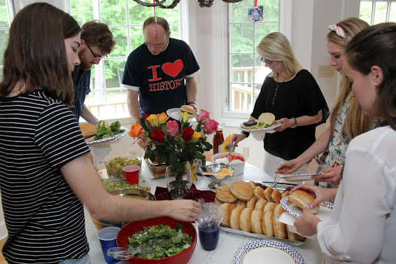 Attendees at the Phi Alpha Theta cookout go around the food table on May 12, 2018. They are (left to right, going clockwise) Brittany Staggs, Luke Sower, Robert Briley, Brenda Briley, Ali Renckens, and Joanna Butcher.