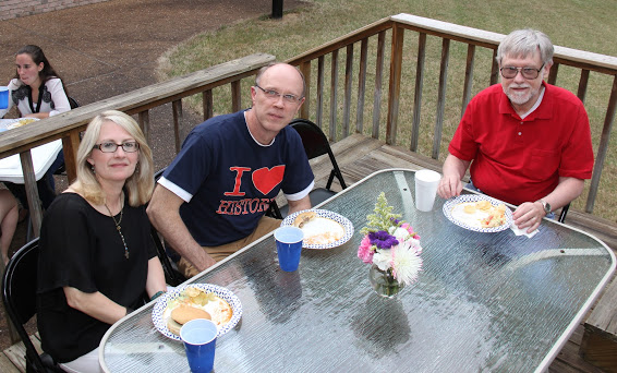 Brenda (left to right) and Robert Briley join with Dr. Terry Lindley for a photo at the Phi Alpha Theta cookout on May 12, 2018. Joanna Butcher is seated in the background on the left.