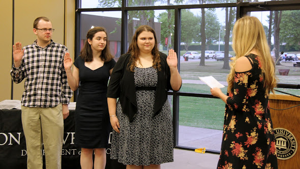Rutledge Honorary History Club President Ali Renckens (right) leads the induction ceremony for the club's 2018-2019 officers at the history awards banquet on May 3, 2018. They are: (left to right) Will Choate, secretary; Leah Atkins, vice president; and Jessica Barton, president. Photo by Katherine Cheshire