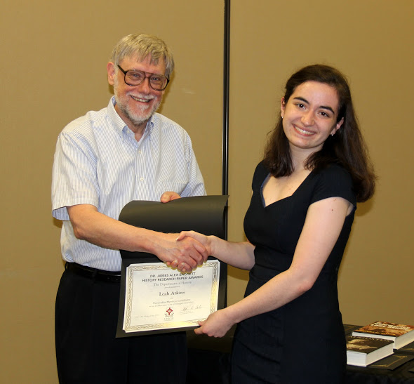 Leah Atkins accepts an honorable mention certificate in the Dr. James Alex Baggett History Research Paper Competition from Dr. Terry Lindley on May 3, 2018. Photo by Katherine Cheshire