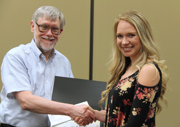 Ali Renckens accepts the third place award in the Dr. James Alex Baggett History Research Paper Competition from Dr. Terry Lindley on May 3, 2018. Photo by Katherine Cheshire