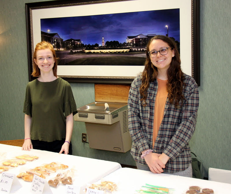 Savannah Wright (left) and Katie Allison stand together just before the start of selling baked good to people exiting chapel on April 10, 2019.
