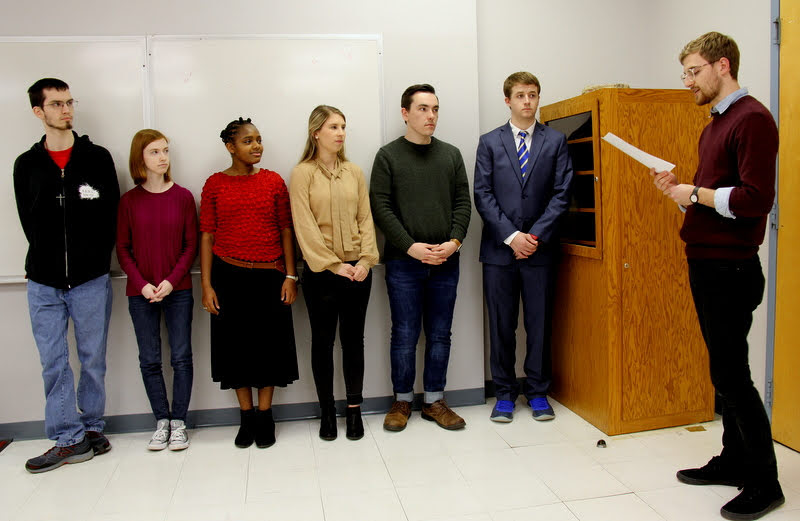 Delta-Psi Chapter Vice President Luke Sower (right) leads the induction ceremony for new Phi Alpha Theta members on February 26, 2019. The initiates are (left to right) Matthew Latham, Savannah Wright, Tranae Newsome, Addison Osborne, Mac Hazlerig, and Reagan Smith.