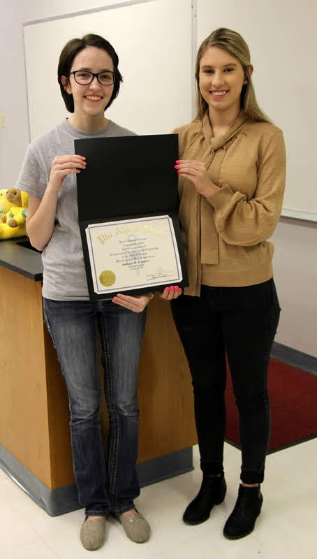 Delta-Psi Chapter President Lauren Butler (left) presents Addison Osborne with her Phi Alpha Theta membership certificate on February 26, 2019.