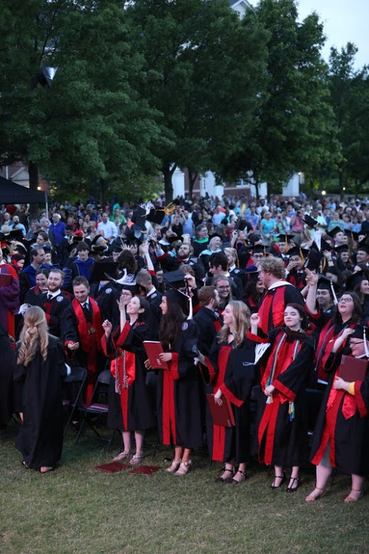 History major Lauren Butler (front row, fifth from right), along with many of her classmates, throws her cap into the air at the end of Union University's undergraduate commencement service on May 18, 2019. Photo by Kristi Woody