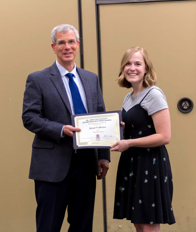 Megan Ledbetter accepts the third-place prize in the Dr. James Alex Baggett History Research Paper Competition from Dr. David Thomas at the history awards banquet on May 2, 2019. Photo by Nicole Grim