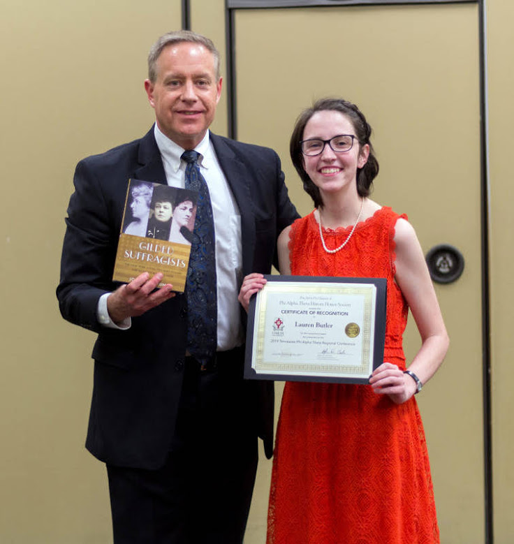 Lauren Butler receives a certificate of recognition and a book from Dr. Henry Allen at the history awards banquet on May 2, 2019, for her paper presentation at the Tennessee Phi Alpha Theta Regional Conference at Belmont University in March. Photo by Nicole Grim
