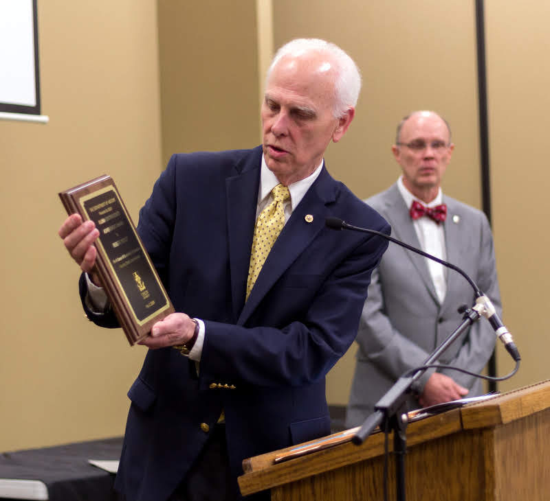 Dr. Stephen Carls reads the inscription on the plaque given to Robert Briley at the history awards banquet on May 2, 2019, as the 11th recipient of the History Alumni Distinguished Achievement Award. Photo by Nicole Grim