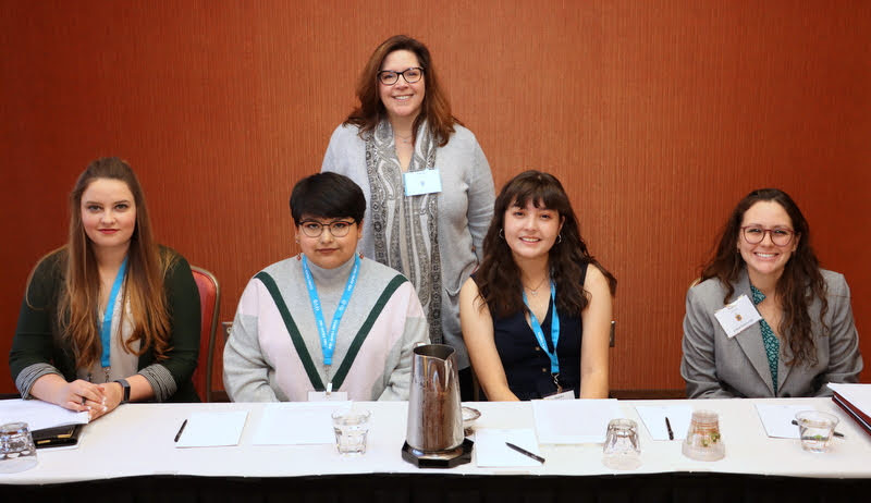 Members of the Phi Alpha Theta convention panel called Gender/Sexuality pose for a photo prior to their session on January 3, 2020. They are (seated, left to right) Allison Draheim, Kendra Garcia, Alondra Morillon, and Katie Allison. Dr. Tiffany Fink (panel chair/commentator) stands behind the student presenters.